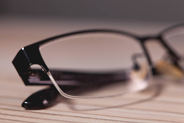 eyeglasses on wooden table with shallow depth of field and copy space
