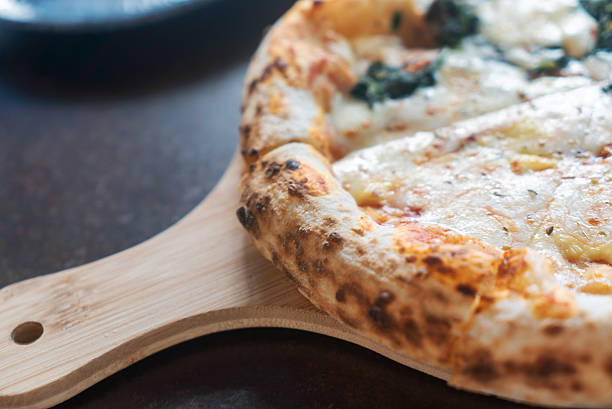 A close-up image of a delicious artisan pizza on a wooden serving board, showcasing the golden crust, melted cheese, and fresh toppings perfect for any meal.