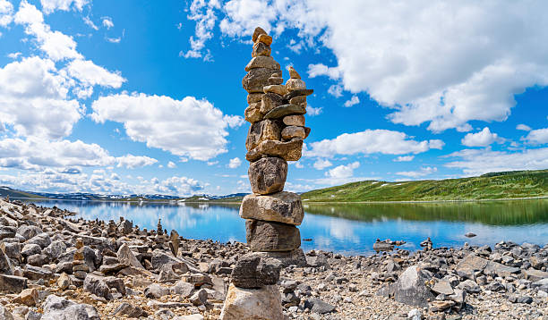 Vardar stone cairns by Orteren lake in summer Norway scenic travel with mountains and nature