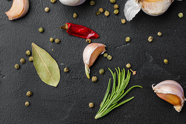 istock Garlic cloves and spices on black background 2236793560