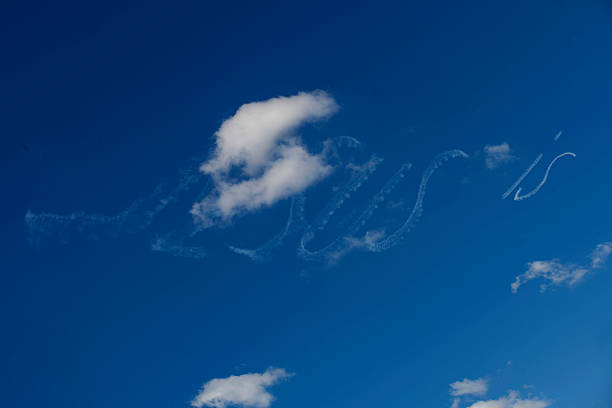 White smoke lines on a blue sky showing the wake turbulence of aerobatic airplane at an airshow