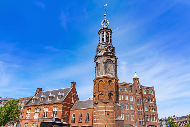 Historic Munttoren clock tower with carillon in Amsterdam, Netherlands, under blue sky on a bright summer day