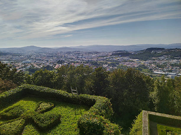 Braga, Portugal: August 14 2023: Group of tourists gathered at a stone viewpoint under large trees in Bom Jesus do Monte Braga, Portugal