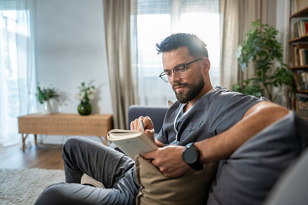 istock Relaxed mid adult man reading book indoors 2236799404