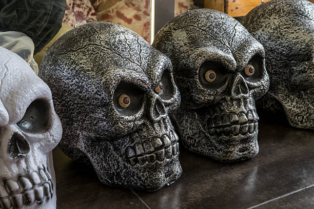 Decorative skulls in various designs arranged on a surface, showcasing intricate details and textures, perfect for Halloween or gothic themes