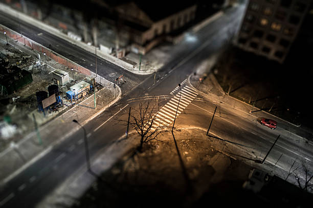 istock Night city intersection with tilt-shift effect and red car in motion 2236802885