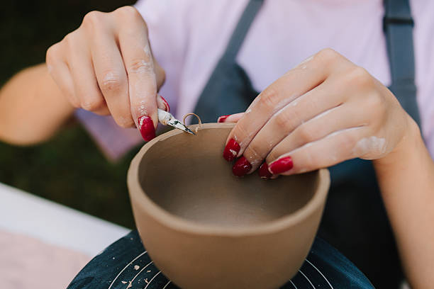 istock Process of sculpting clay bowls blends precision with creativity, highlighting craftsmanship and ceramic traditions. Pottery carving close-up. Artistry of carving clay pottery is shown in detail. 2236804183