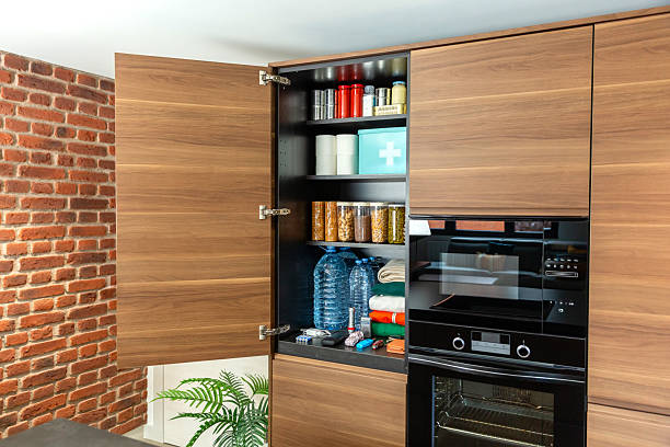 Open kitchen drawer with arranged set of cutlery and cooking utensils in wooden organizer. Contemporary kitchen cabinet. Concept of home organization and kitchen efficiency