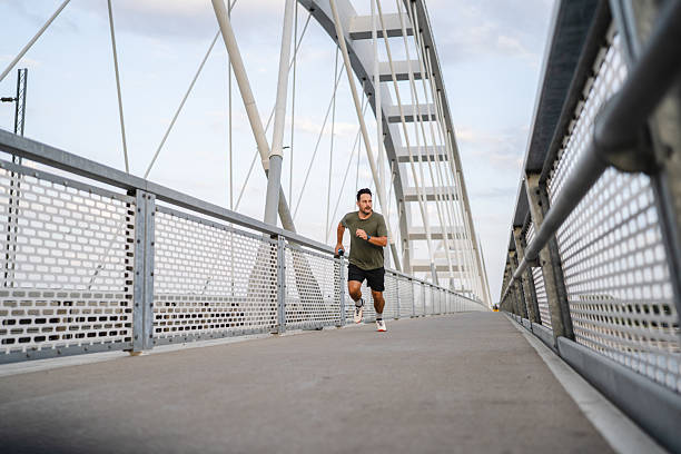 istock Man jogging on a modern urban bridge exercising 2236809668