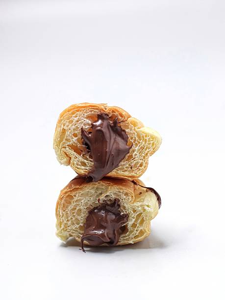 Delicious chocolate-filled croissant on white background, French pastry close-up.