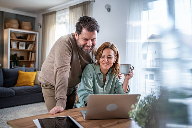 istock Mature couple enjoying spending time together using laptop at home 2236814132