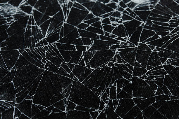 istock Broken glass texture with intricate crack patterns on a black background. The detailed shards and broken lines form a dramatic abstract motif, suitable for concepts of damage, destruction, and shards. 2236819397