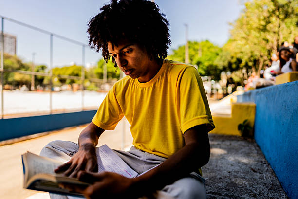 istock Young man studying reading a book at the park 2236822913