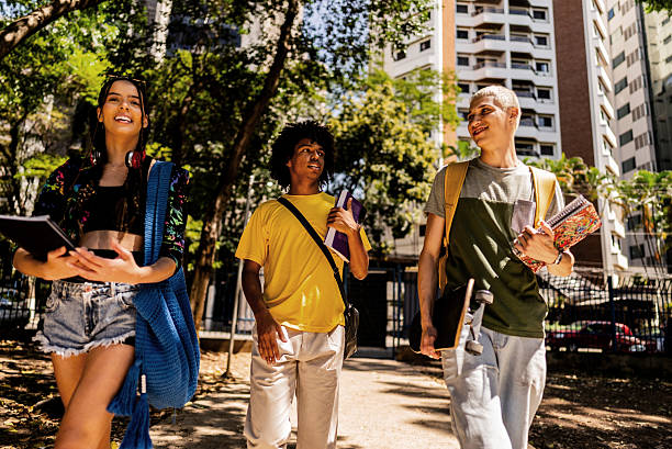 istock Young friends talking while walking in the street 2236822931