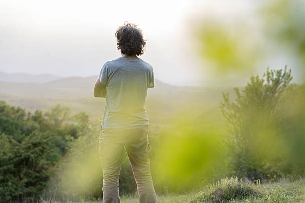 istock Man Contemplating The Sunset In Nature, Rear View 2236822958
