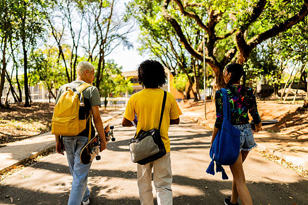 istock Young friends talking while walking at the park 2236823112