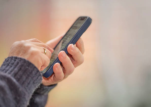 istock Close-up View of Hand Using Smartphone with a Blurred Background 2236823117