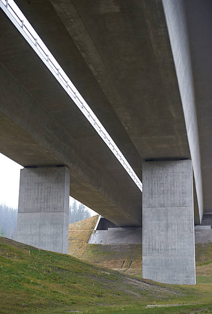 istock Elegant concrete bridge construction spanning scenic meadow with forested background 2236823206