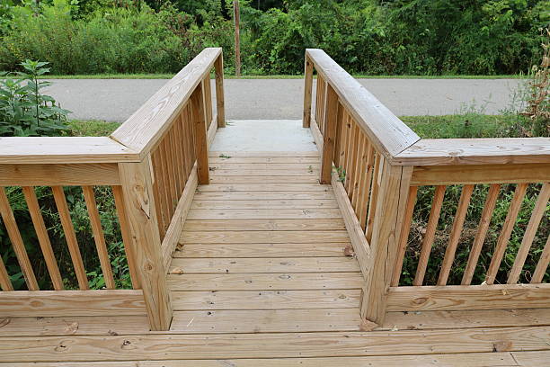 Wooden deck with bannisters leading to nature park walking path