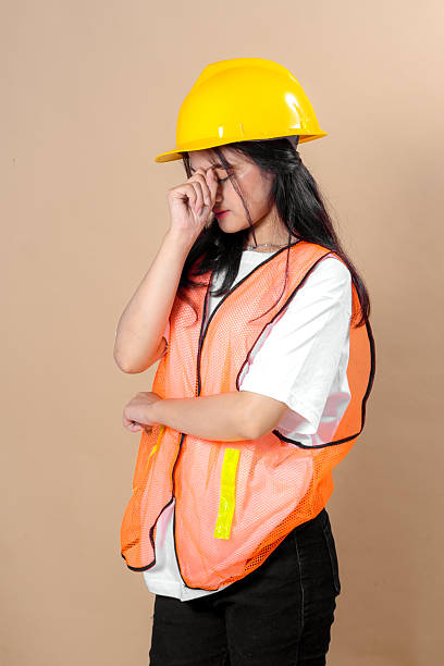 istock Young Construction Worker Wearing Orange Safety Vest And Yellow Hard Hat, Smiling For A Studio Portrait 2236826389