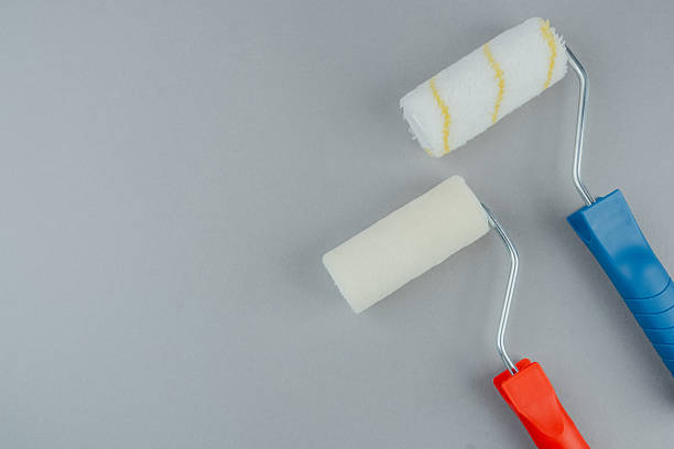 istock Two paint rollers with red and blue handles on gray background for home improvement and DIY painting concept 2236827226