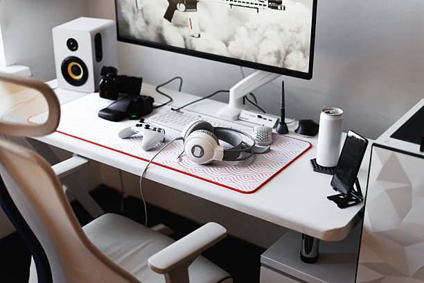 istock High-tech gaming desk with minimalistic white aesthetic, perfect lighting, and intuitive cable management. Gamer maintains focus and efficiency with optimal workspace for both gaming and streaming. 2236829805
