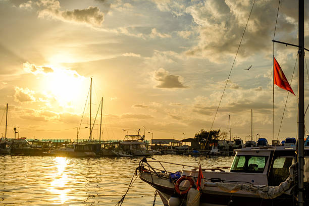 Erdek, Turkey - February 8, 2024 : Erdek Town harbor with ships at sunset with amazing sky