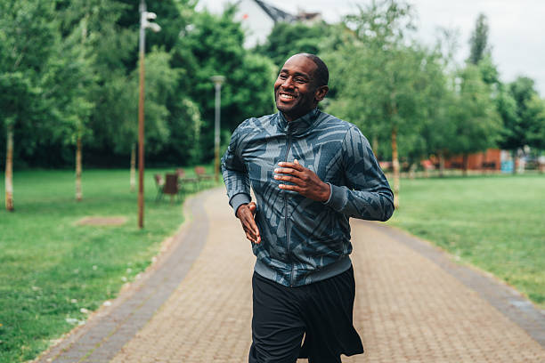 istock Smiling man jogging outdoors in the park. 2236834820
