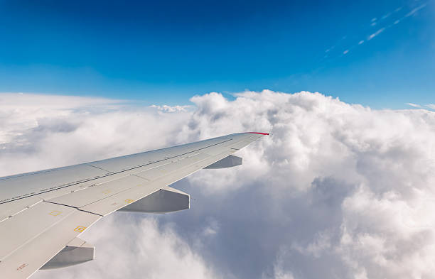 istock View from the airplane window at a beautiful cloudy sky and the airplane wing 2236836418