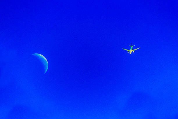A plane soars past the crescent moon in a clear blue sky in Sydney, NSW, Australia. (Photo by Tara Chand Malhotra)
