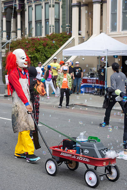 San Francisco, CA, USA - May 14, 2022: This 12K race is one of the largest and oldest running events in the world. It attracts more than 50,000 runners and 100,000 spectators every year. This race includes both serious runners and those out for a fun Sunday run. Many wear fun and funky costumes to show their spirt. You will also find a few people in just their birthday suit. People dressed like clown with bubble machine.