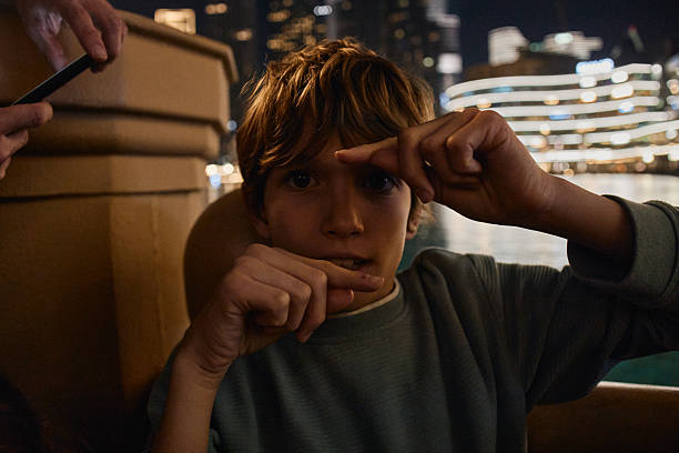 Pensive Caucasian boy looking through a window
