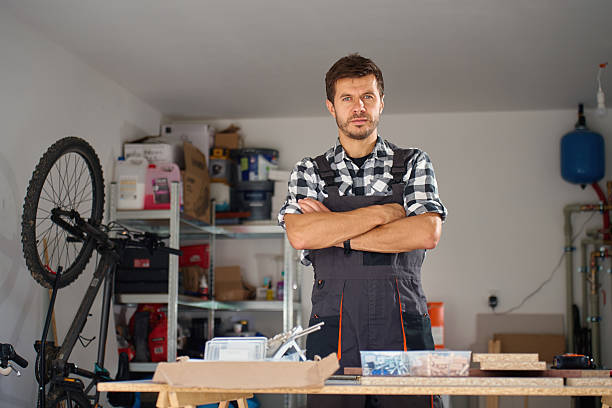 istock Carpenter standing with crossed arms in home workshop with tools and materials 2236842397