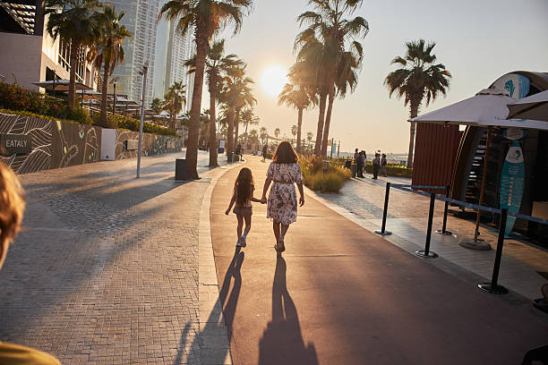 istock Mother and daughter walking at sunset along dubai boardwalk 2236845428