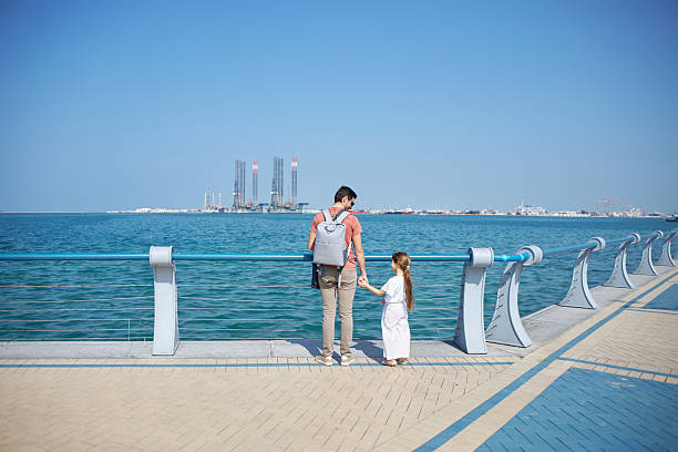 istock Father and daughter holding hands enjoying promenade view 2236846158