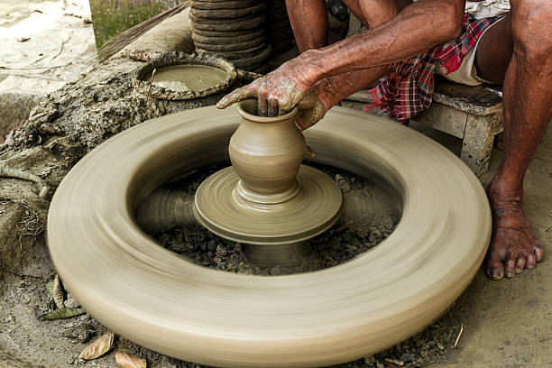 Artisan shaping pottery on a spinning wheel highlights traditional crafting techniques and creativity.