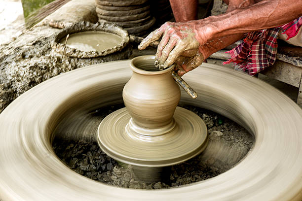 Artisan shaping pottery on a spinning wheel highlights traditional crafting techniques and creativity.