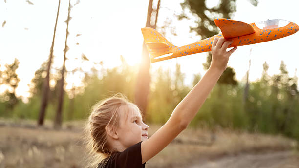 istock Kid with toy plane is playing at sunset. 2236848194