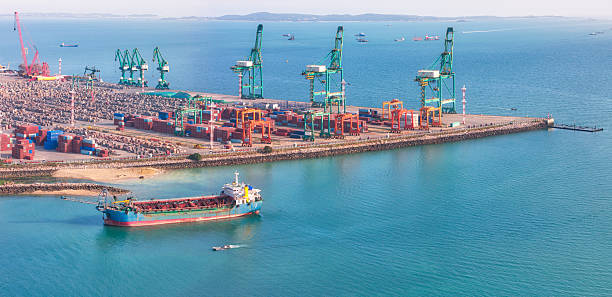 istock A bustling container port with a cargo ship docked at the terminal, featuring large cranes and stacked shipping containers along the waterfront 2236848373