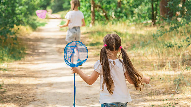 Curious children seeking and catching insects with a net