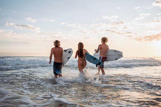 istock Caucasian Friends Joyfully Running Surfing Waves 2236849467