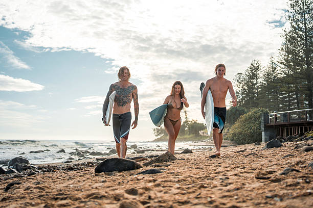 istock Caucasian Surfers Joyfully Walking on Beach at Sunrise 2236849513
