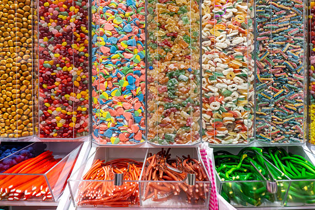 istock Colorful gummies, candies, marshmallows, and sweets in transparent shop containers, assorted confectionery products displayed for sale. 2236849898