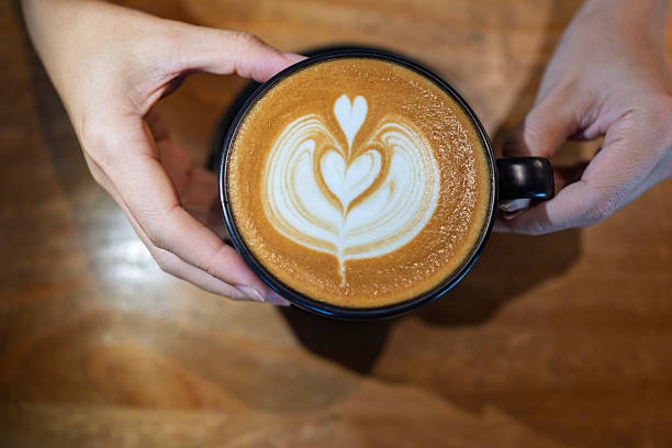 istock Barista serving hot latte with heart-shaped latte art 2236852439