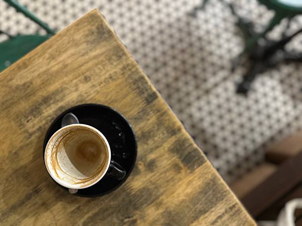 A finished coffee-stain cup on a wooden table.