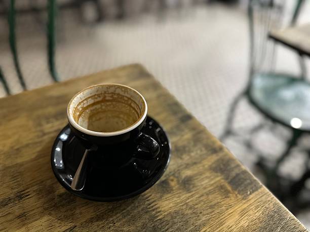 A finished coffee-stain cup on a wooden table.