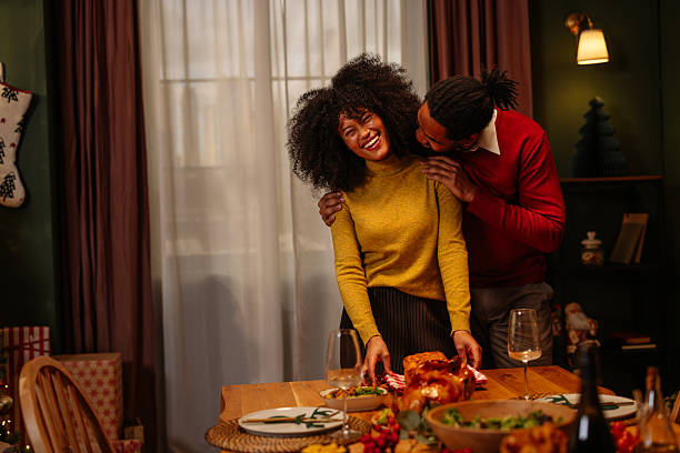 istock Couple preparing Christmas dinner table, arranging roasted turkey 2236853786