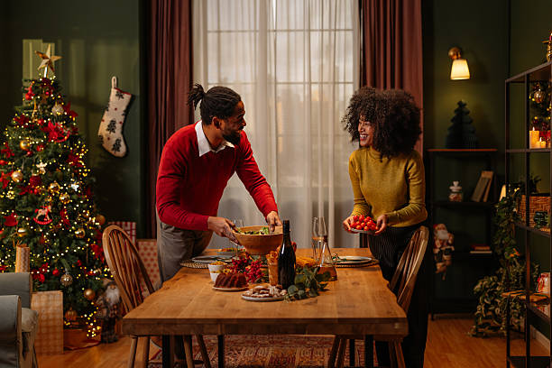 istock Couple Setting Christmas Dinner Table at Home 2236853788