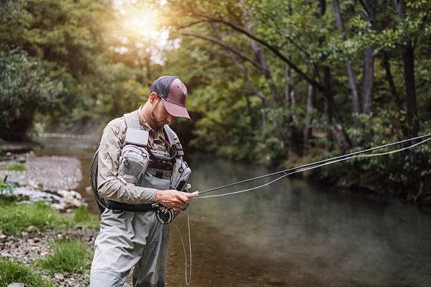 istock Man fly fishing in misty river enjoying nature 2236854877