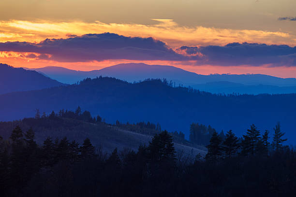 istock Layered mountain ranges illuminated by vibrant sunrise, casting long shadows in the twilight scenery. 2236855287